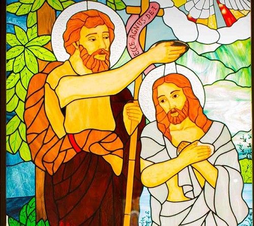 Uno de los vitrales de la iglesia muestra a San Juan Bautista bautiza a Jesús
