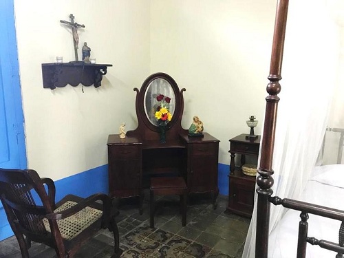 Crucifijo y mueble de época en el dormitorio del matrimonio Sandino Tiffer